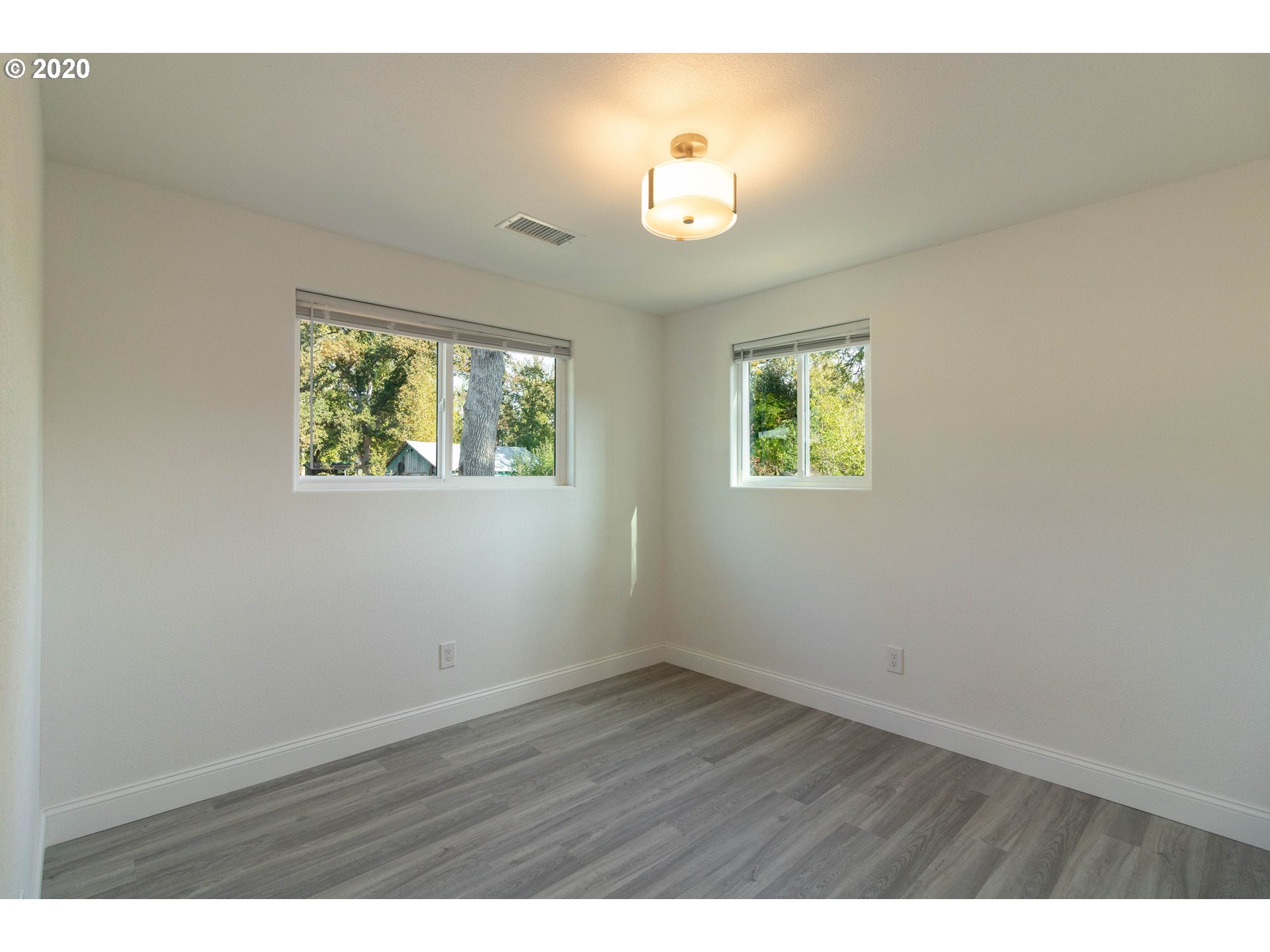 3373 Melrose Road Roseburg, OR 97471 - Photo 20 of 32 an empty room with wooden floor and windows