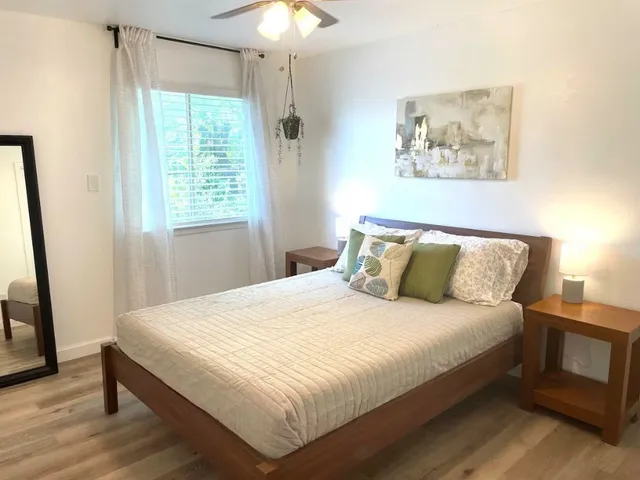 a large bed sitting in a bedroom next to a window