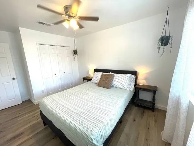 a spacious bedroom with a bed and a chandelier