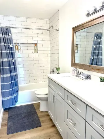 a bathroom with a double vanity sink a toilet and shower