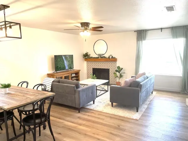 a living room with furniture a fireplace and a flat screen tv