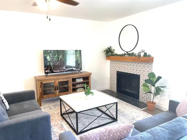 a living room with furniture a fireplace and a piano