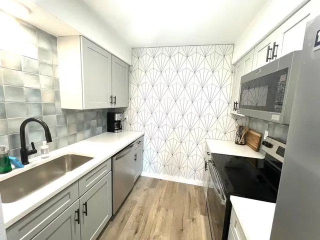 a kitchen with a sink a stove and cabinets