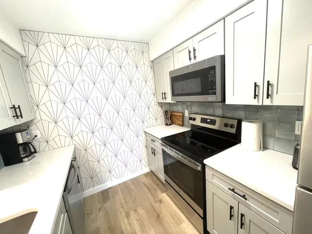 a kitchen with a stove a sink and a microwave