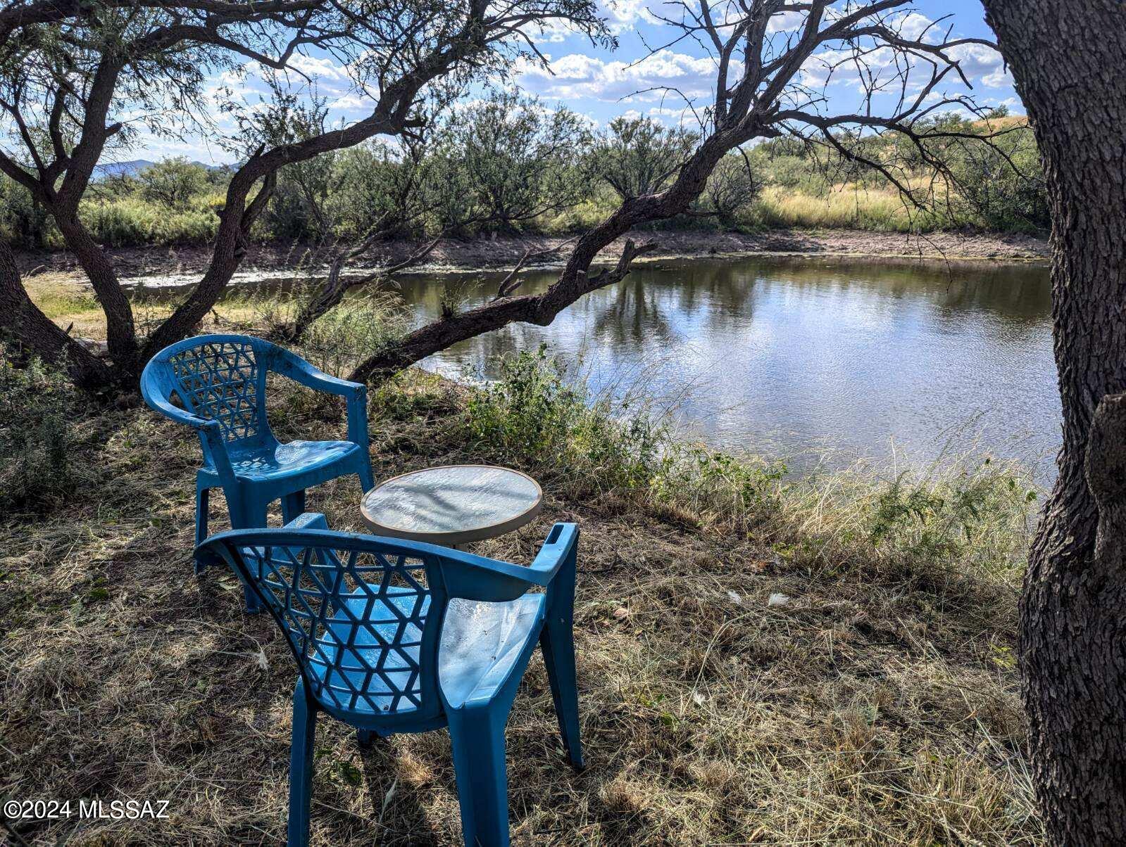 35700 South Cedar Creek Road Arivaca, AZ 85601 - Photo 27 of 44 a backyard of a house with table and lake view