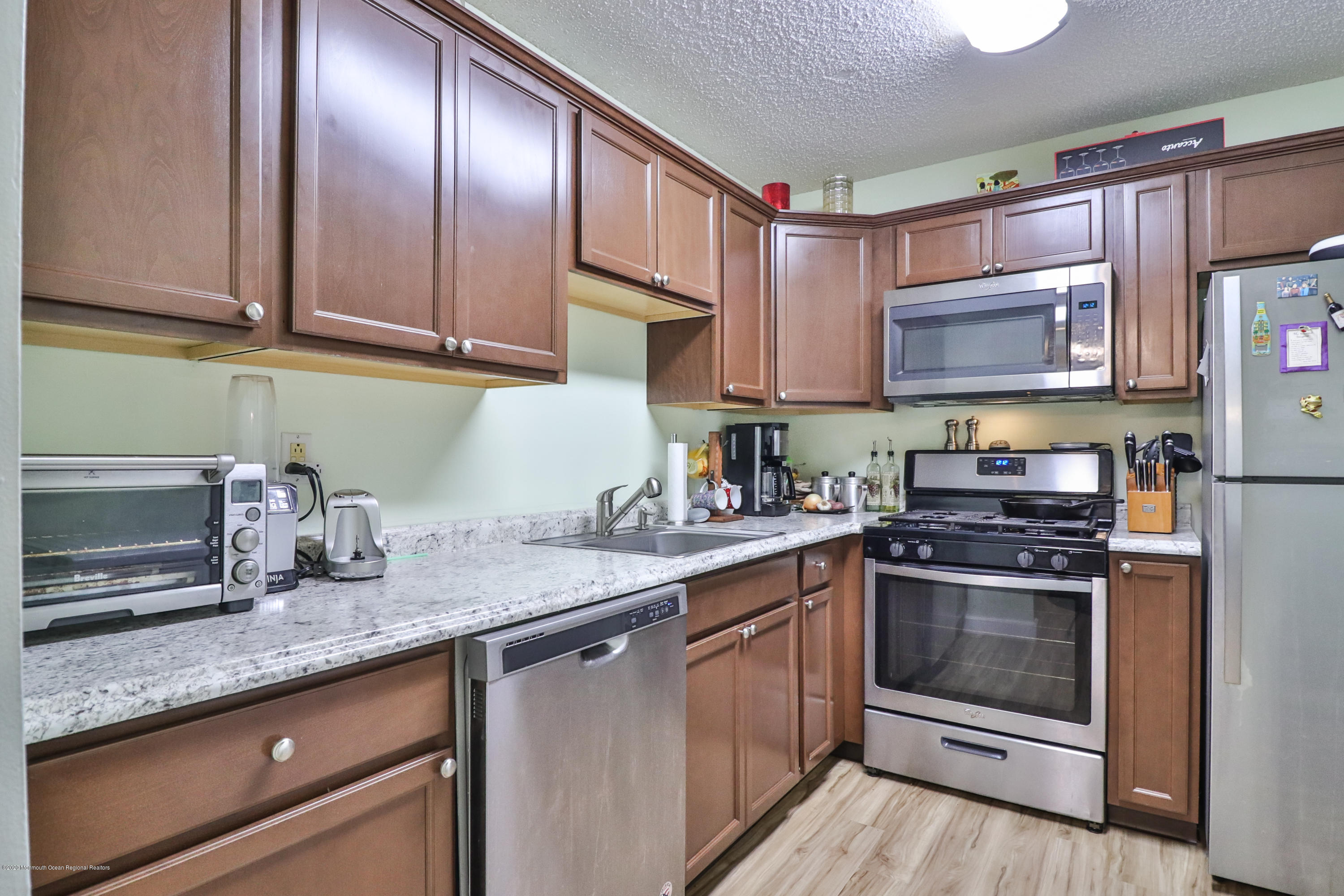 704 Violet Lane Jackson, NJ 08527 - Photo 4 of 20 a kitchen with granite countertop stainless steel appliances and wooden cabinets