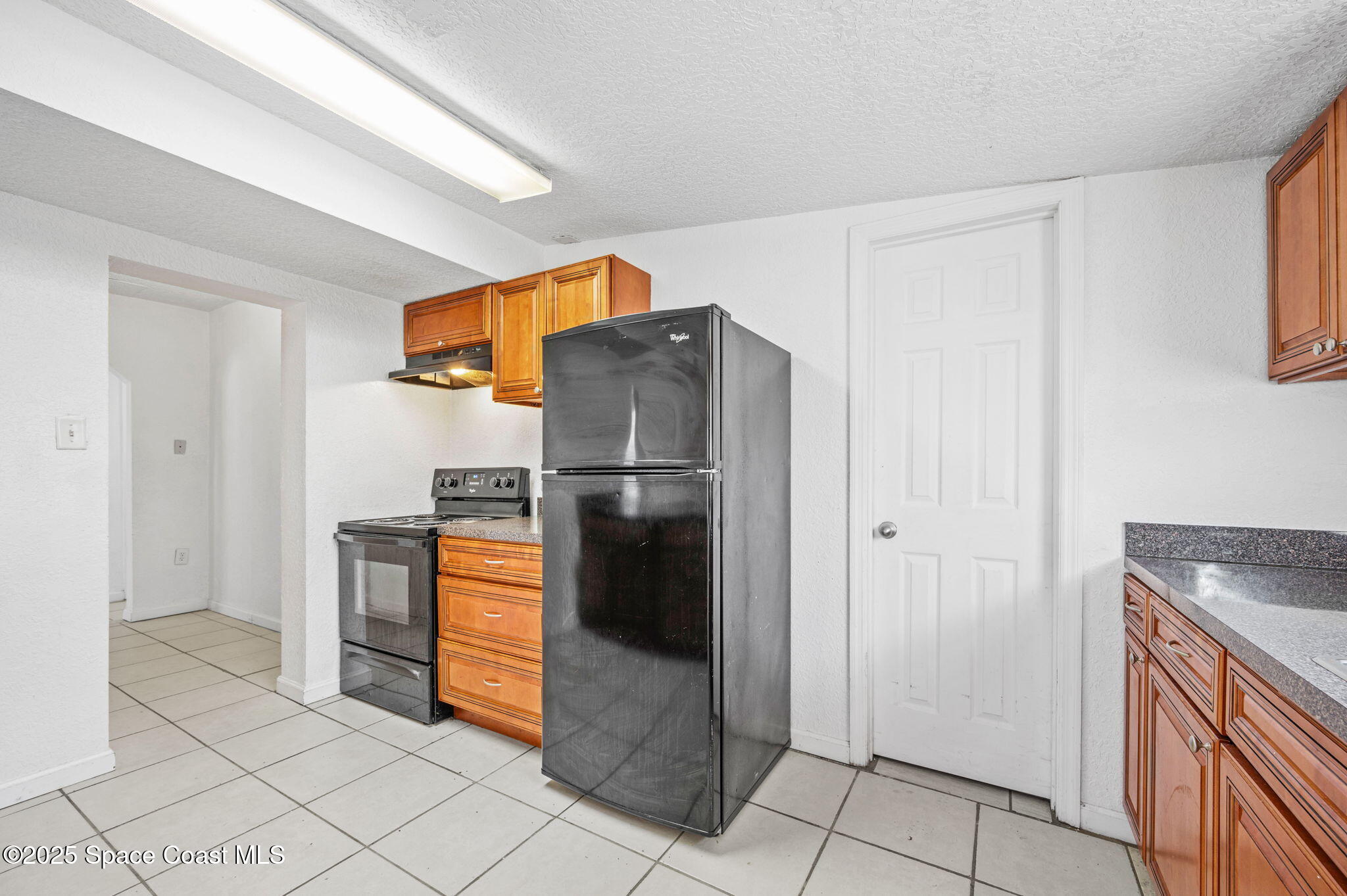 907 Espanola Way Melbourne, FL 32901 - Photo 11 of 31 a kitchen with stainless steel appliances granite countertop a refrigerator and a sink
