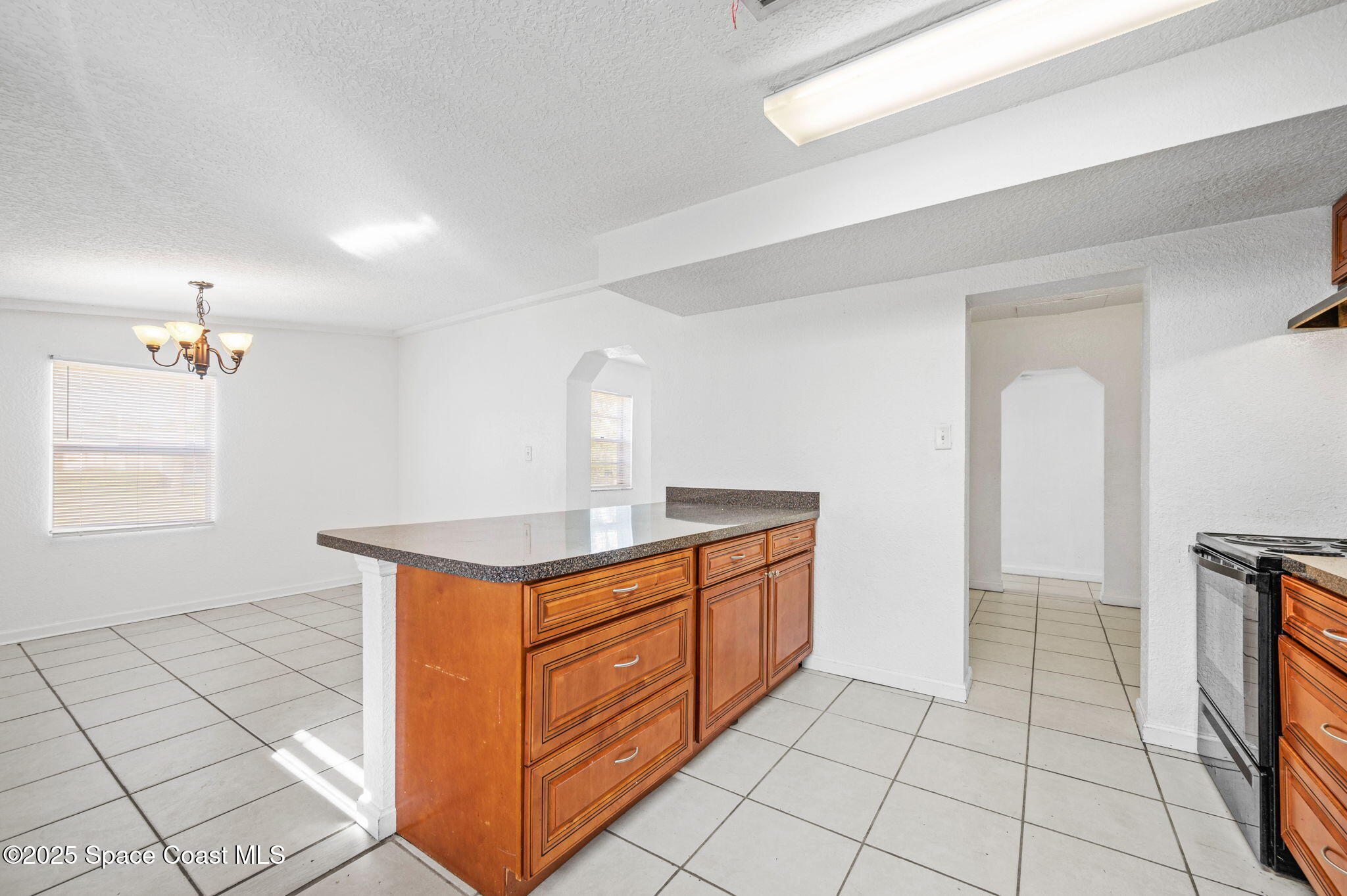 907 Espanola Way Melbourne, FL 32901 - Photo 12 of 31 a kitchen with stainless steel appliances granite countertop a stove a sink and a refrigerator
