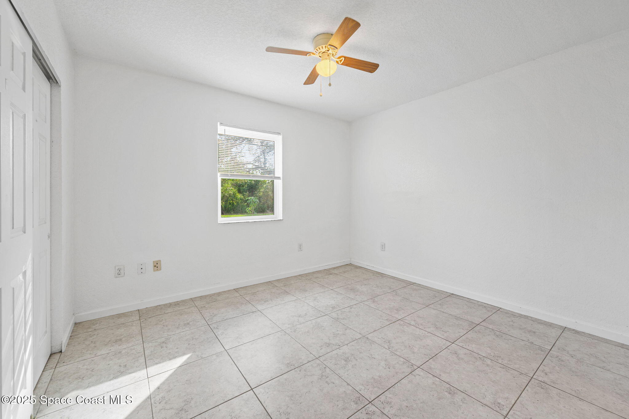 907 Espanola Way Melbourne, FL 32901 - Photo 29 of 31 an empty room with a window and a fan