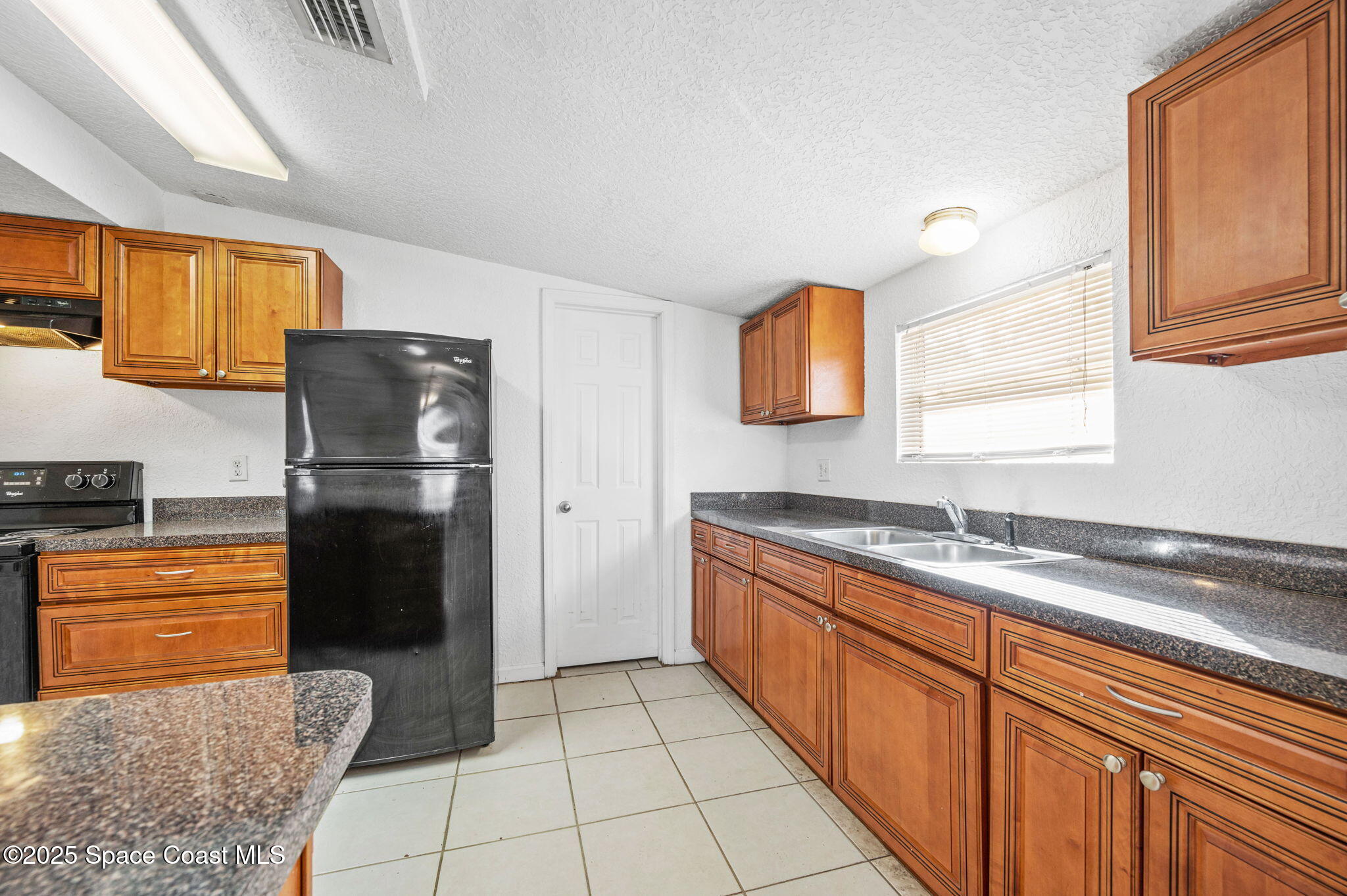 907 Espanola Way Melbourne, FL 32901 - Photo 10 of 31 a kitchen with stainless steel appliances granite countertop a refrigerator and a sink