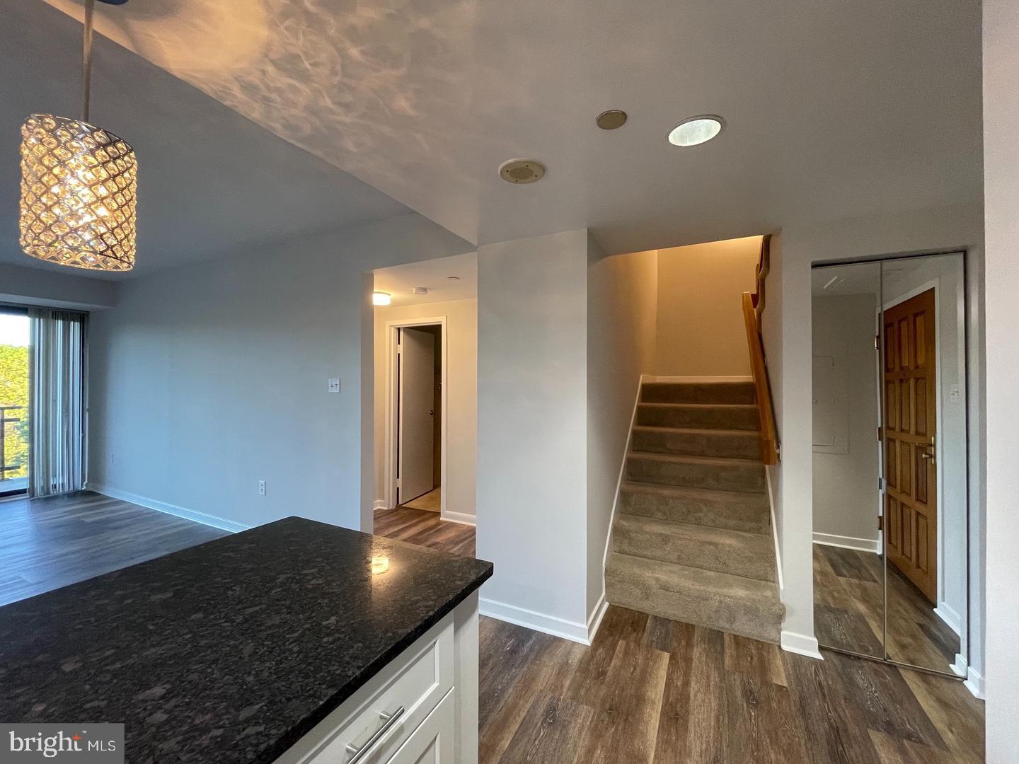 1530 Key Boulevard, Unit 326 Arlington, VA 22209 - Photo 24 of 47 a view of a hallway to an empty room with wooden floor and staircase