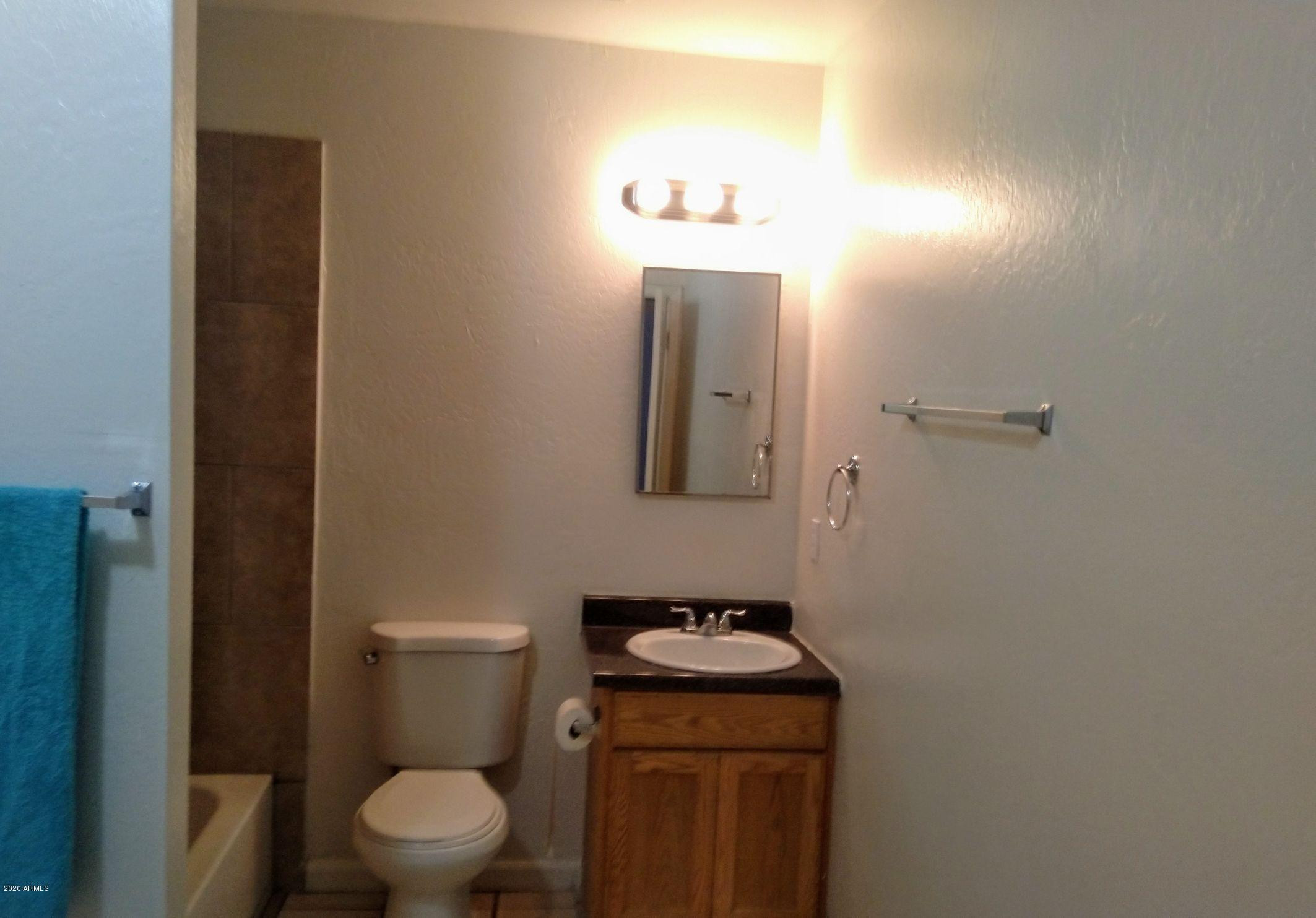 2133 West Adams Street, Unit 3 Phoenix, AZ 85009 - Photo 7 of 10 a bathroom with a toilet a sink and mirror
