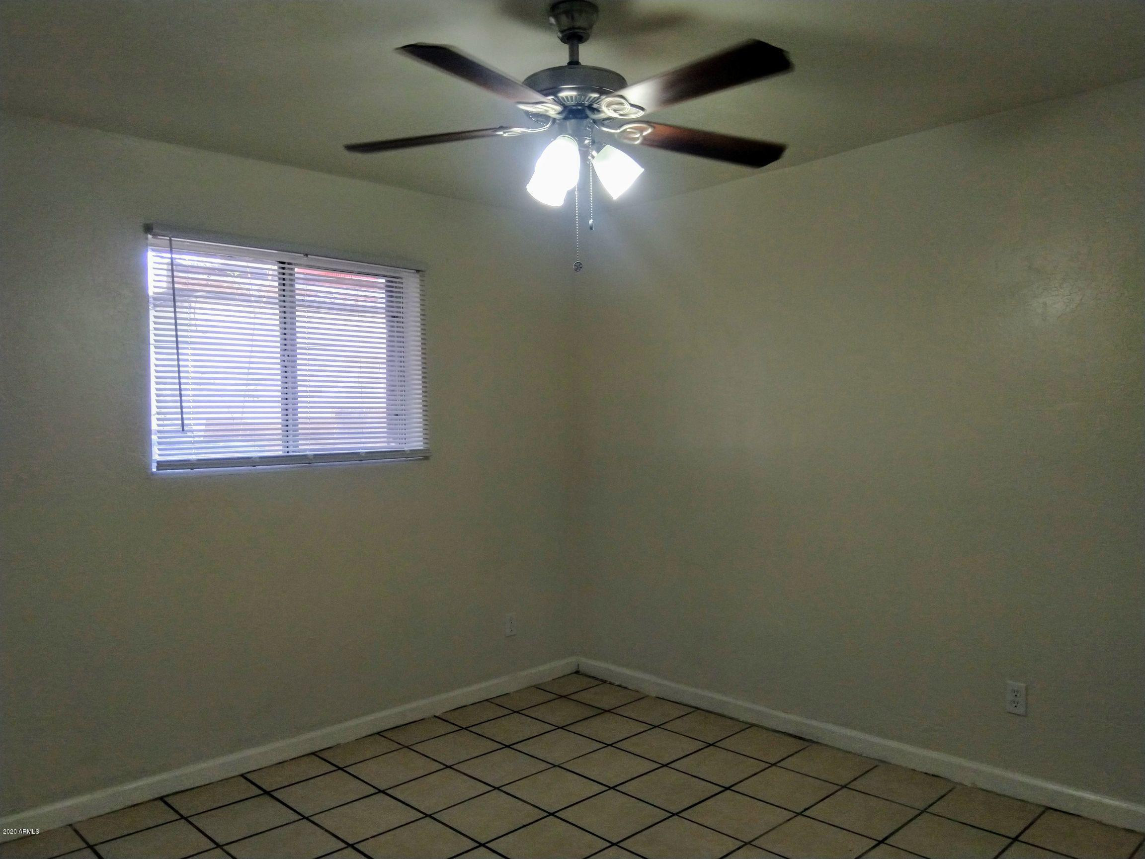 2133 West Adams Street, Unit 3 Phoenix, AZ 85009 - Photo 8 of 10 an empty room with a window and a fan