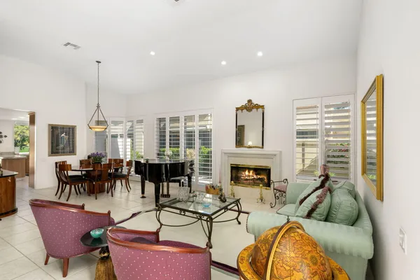 a living room with fireplace furniture and a large window