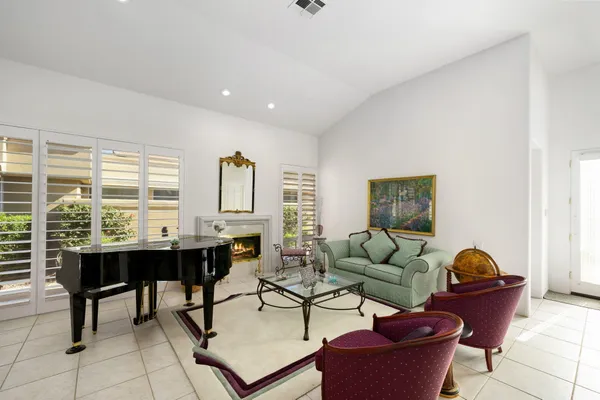 a living room with fireplace furniture and a large window