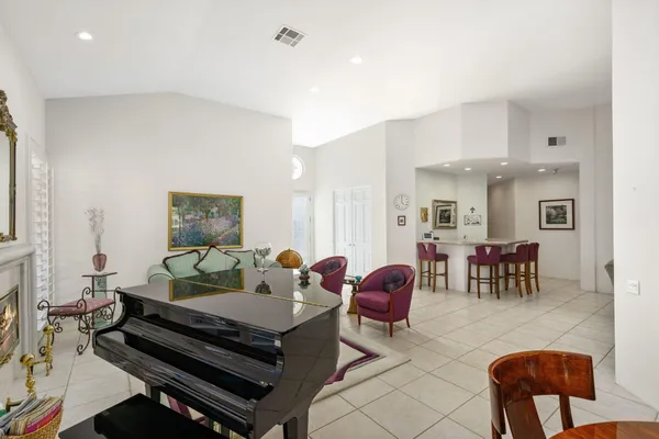 a reading room with furniture a rug and a fireplace