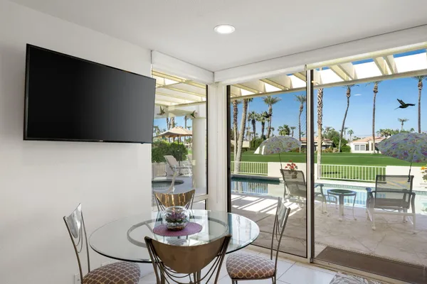 a dining room with furniture and a floor to ceiling window