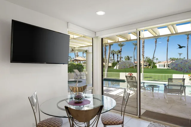 a dining room with furniture and a floor to ceiling window