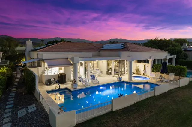 a view of a house with swimming pool and sitting area