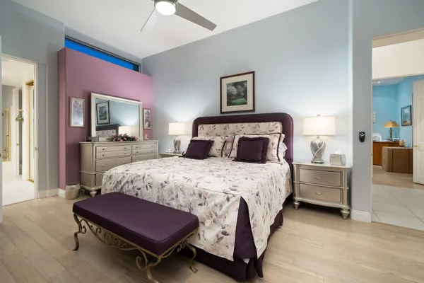 a bedroom with a bed a chandelier and a dresser