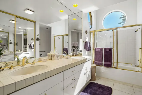a spacious bathroom with a double vanity sink mirror and shower