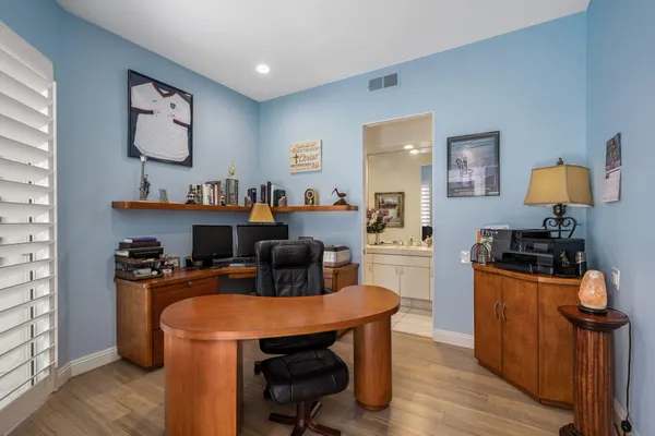 a view of a workspace with furniture and wooden floor