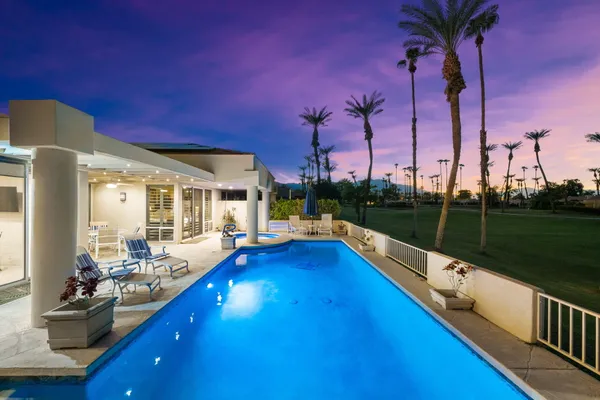 a view of a house with swimming pool and sitting area