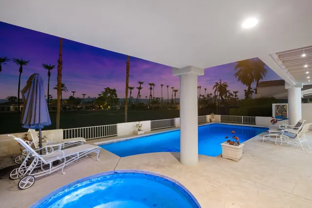 a view of swimming pool with seating space and fir pit