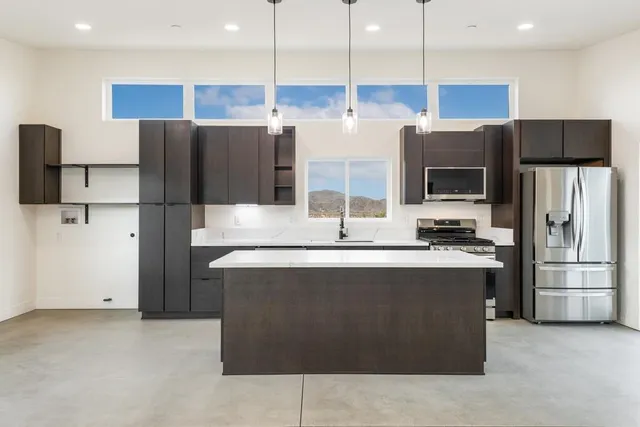 a view of kitchen with stainless steel appliances granite countertop cabinets and wooden floor