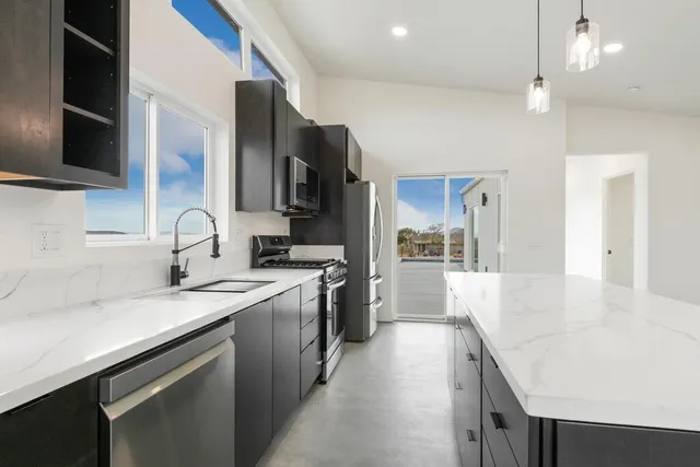 a kitchen with stainless steel appliances a sink stove and cabinets