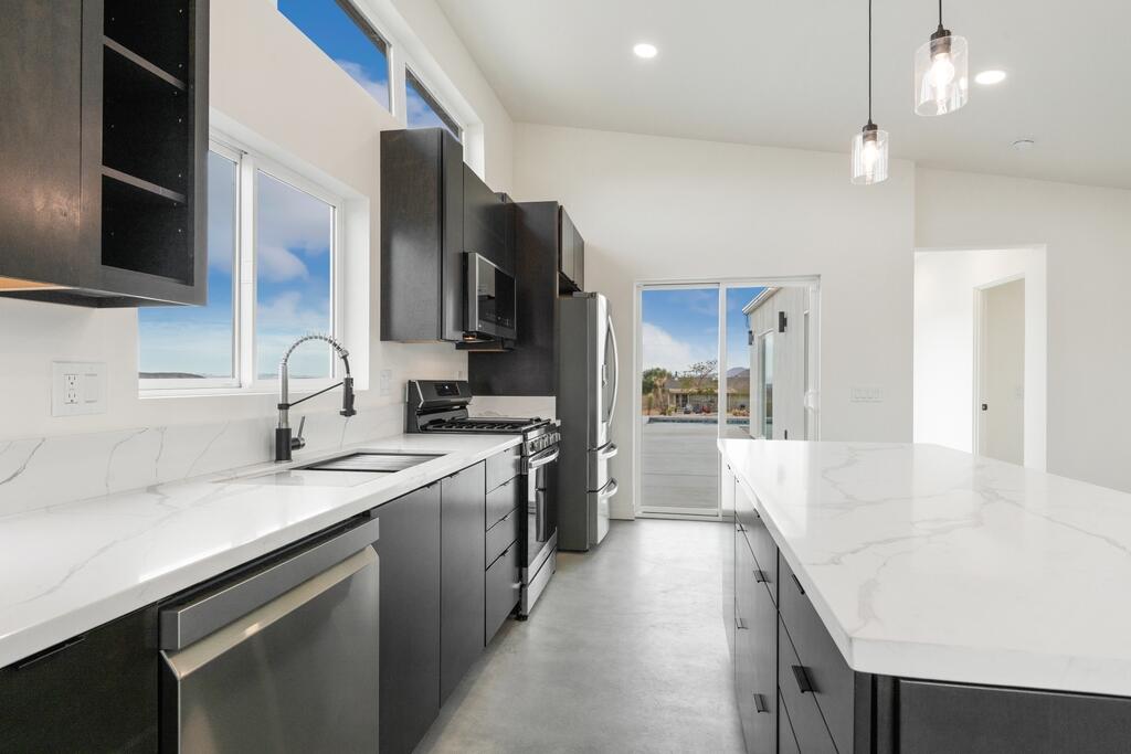6689 Torres Avenue Joshua Tree, CA 92252 - Photo 14 of 48 a view of a kitchen with a sink and dishwasher a stove top oven with wooden floor