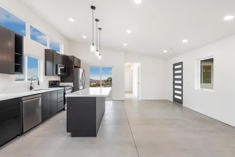 a kitchen with stainless steel appliances a refrigerator sink and microwave