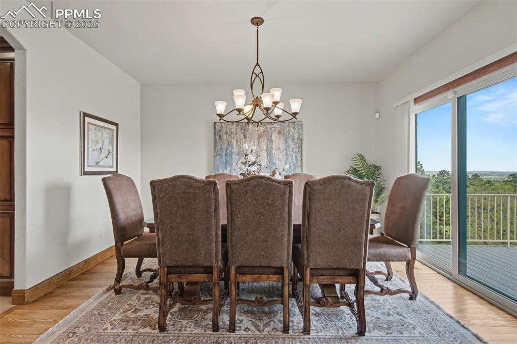 4215 Star Ranch Road Colorado Springs, CO 80906 - Photo 19 of 44 a view of a dining room with furniture wooden floor and a chandelier