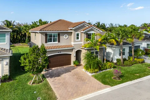 a front view of a house with a yard and potted plants