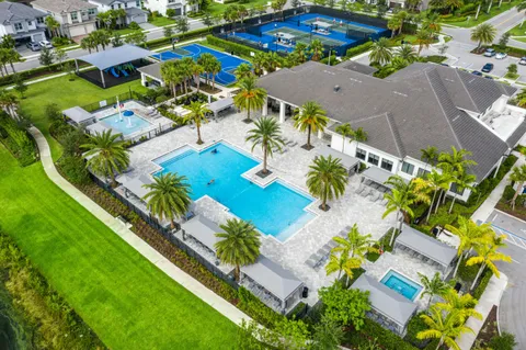 a view of a swimming pool with a lounge chair and palm trees