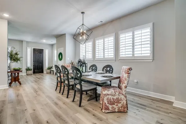 a view of a a dining room with furniture window and wooden floor