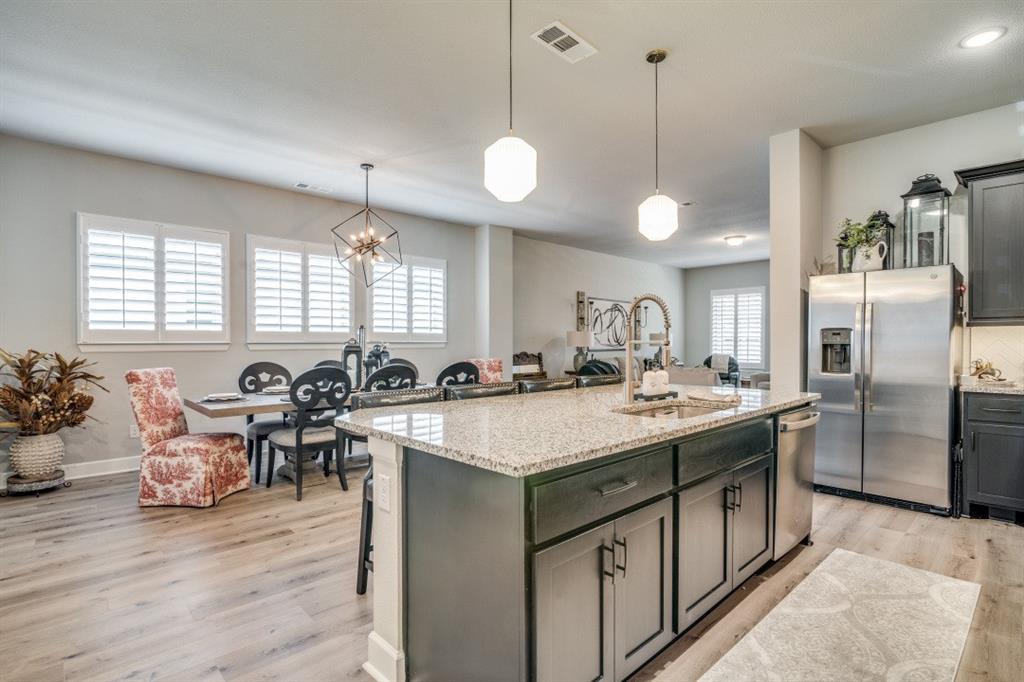 1268 Caprock Drive Forney, TX 75126 - Photo 19 of 35 a kitchen with stainless steel appliances granite countertop a stove and a center island