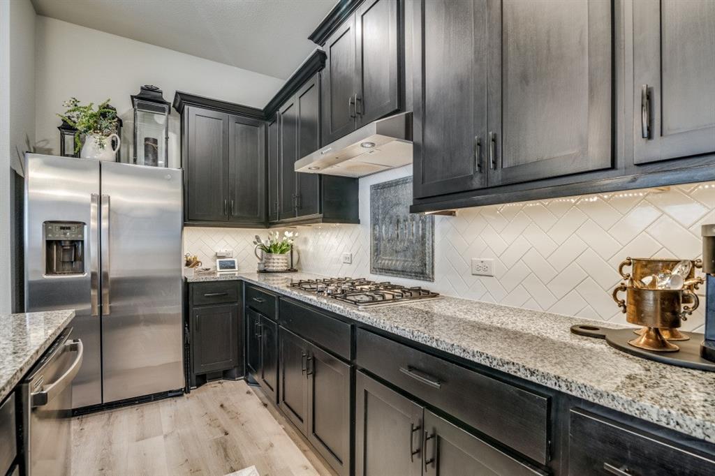 1268 Caprock Drive Forney, TX 75126 - Photo 20 of 35 a kitchen with granite countertop stainless steel appliances a sink counter space and cabinets