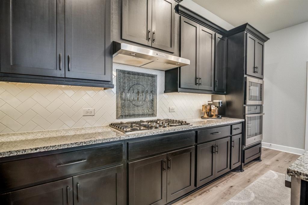 1268 Caprock Drive Forney, TX 75126 - Photo 21 of 35 a kitchen with granite countertop a stove and a sink