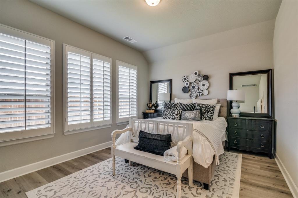 1268 Caprock Drive Forney, TX 75126 - Photo 23 of 35 a bedroom with a large bed and a window