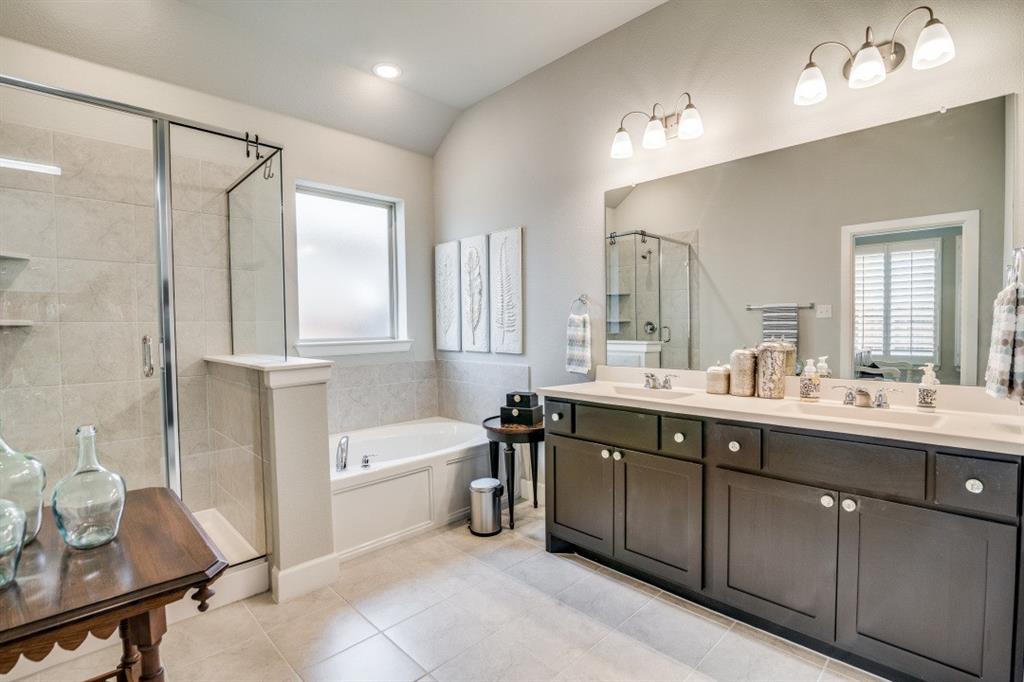 1268 Caprock Drive Forney, TX 75126 - Photo 25 of 35 a bathroom with a double vanity sink a mirror and a bathtub
