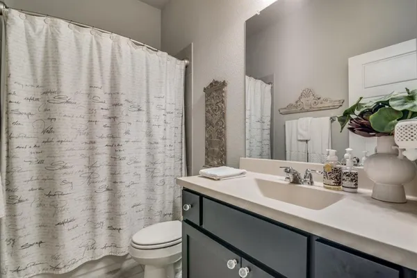 a bathroom with a sink a toilet and a mirror