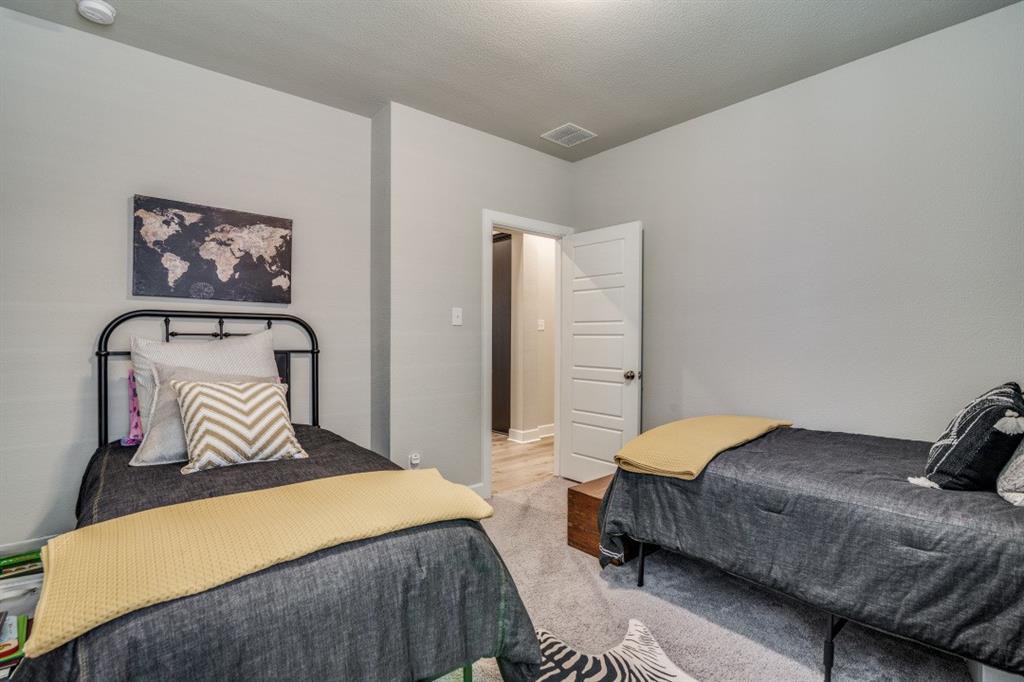 1268 Caprock Drive Forney, TX 75126 - Photo 32 of 35 a bedroom with a bed and a mirror