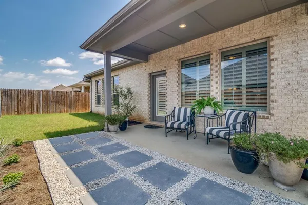 a view of a patio with furniture and a garden