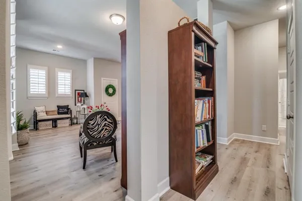 a living room with furniture a bookshelf and a window