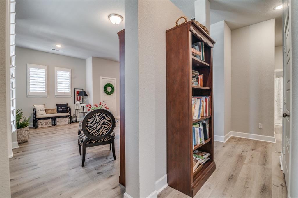 1268 Caprock Drive Forney, TX 75126 - Photo 7 of 35 a living room with furniture a bookshelf and a window