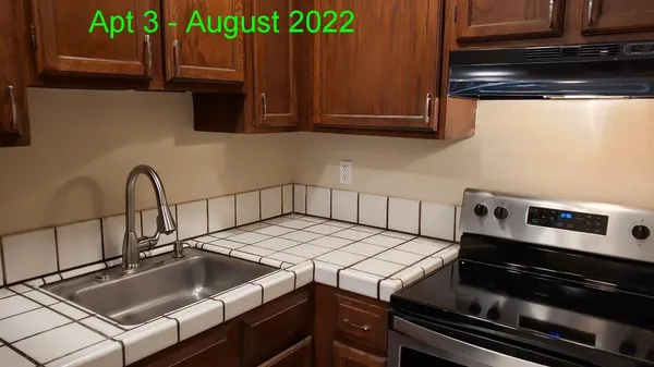 a kitchen with kitchen island granite countertop a refrigerator a sink and a stove