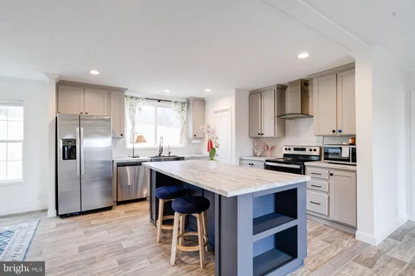a kitchen with stainless steel appliances kitchen island granite countertop a sink and cabinets