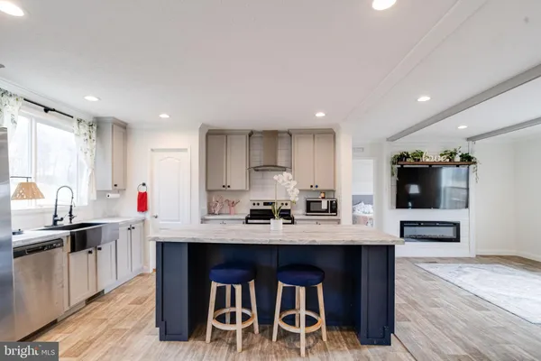 a kitchen with stainless steel appliances granite countertop a kitchen island a stove and a sink