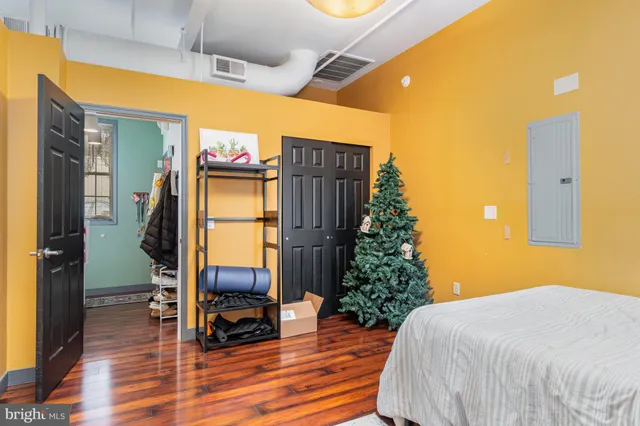 a bedroom with a bed and wooden floor